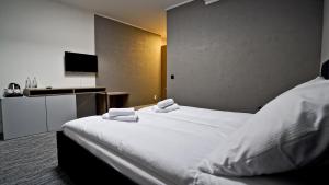 een slaapkamer met een groot wit bed en handdoeken bij Hotel Made in Napoli by Siervo Międzybórz in Neumittelwalde
