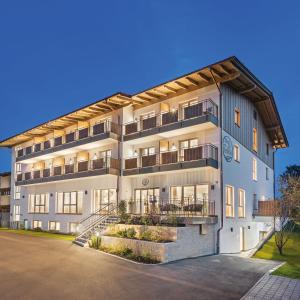 an apartment building with a staircase in front of it at Hotel Seeblick in Obing