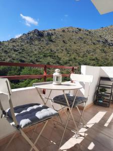 a table and chairs on a balcony with a mountain at Cozy estudio "Edificio Siesta 2" in Alcudia