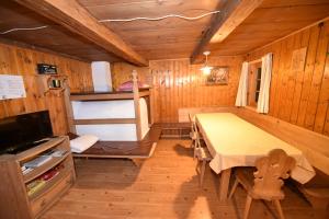 una camera con un tavolo e un letto in una cabina di Gallfallalm a Santa Maddalena in Casies Valbassa