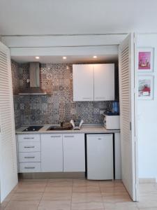 una cocina con armarios blancos y fregadero en Cozy estudio "Edificio Siesta 2" en Alcúdia