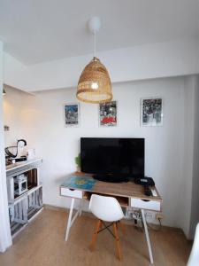阿爾庫迪亞的住宿－Cozy Estudio II. Edificio Siesta 2，一张桌子、一台电视和一张白色椅子