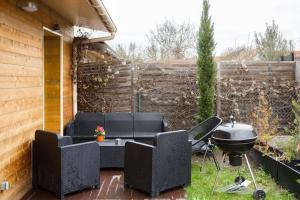 een achtertuin met een barbecue en stoelen bij L'escapade parisienne in Aulnay-sous-Bois