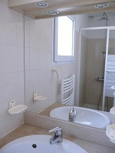 La salle de bains est pourvue d'un lavabo, d'une baignoire et d'un miroir. dans l'établissement Magnifique villa face au golf avec piscine au sel, à Lacanau