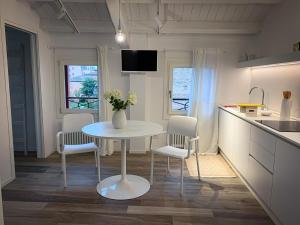 kuchnia ze stołem, 2 krzesłami i stołem w obiekcie Al Sagraeto White apartment w mieście Chioggia