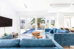 sala de estar con sofás azules y TV en Casa Bos Dolpfin Wellness Luxury Entire Villa Pool & Jacuzzi Gran Alacant near Beach, en Puerto Marino