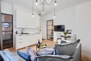 a living room with a couch and a kitchen at Apartament Lu Lu in Sopot