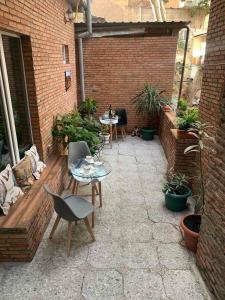 a patio with tables and chairs and a brick wall at Griboedov 13 in Tbilisi City