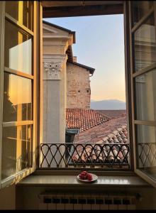 a plate of fruit sitting on a balcony with a view at Domus Dea Città Alta in Bergamo