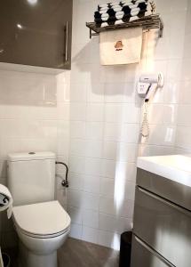 ein weißes Bad mit einem WC und einem Waschbecken in der Unterkunft Le Gîte du Sommerberg in Niedermorschwihr