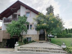 a house with a staircase in front of it at Apartman Jasmin in Čatrnja