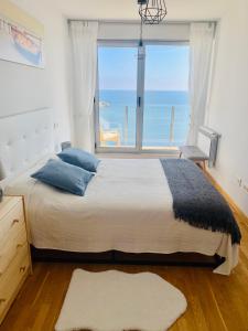 um quarto com uma cama grande e uma janela grande em Apartamentos la Marosa Delux em Burela de Cabo