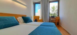 Un dormitorio con una cama y un escritorio y una ventana. en Boavista Class Inn, en Oporto
