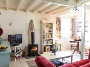 a living room with a fireplace and a couch at Pass The Keys Ian's Cottage, Wedmore - country cottage for two in Wedmore