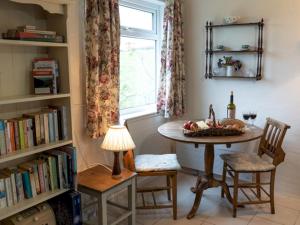 a room with a table and a window and a table and chairs at Pass The Keys Ian's Cottage, Wedmore - country cottage for two in Wedmore