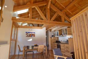 una cucina con soffitti in legno, tavolo e sedie di Petit Chalet Montagne a Briançon