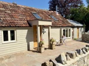 een klein wit huisje met een dak bij Pass The Keys Goose Feather Barn, Wedmore luxury cottage for two in Wedmore