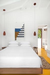 a bedroom with a large white bed with white pillows at Miradouro de São Sebastião in São Sebastião