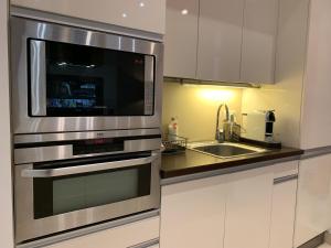 a kitchen with a stainless steel microwave and a sink at Budapest Downtown in Style - Luxury Apartment in Budapest