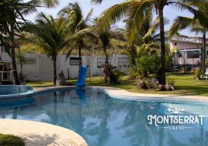 una piscina in un cortile con palme di Villas Monserrat a Guadalupe