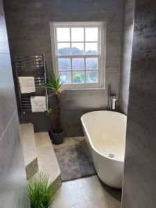 a bathroom with a white tub and a window at Newgate House in Morpeth +15 photos