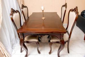 une table à manger en bois avec deux chaises et une bougie sur le dessus dans l'établissement Residence Le Bonheur - 2 Bed Apartment by Douala Mall/Airport, à Douala 18 autres photos