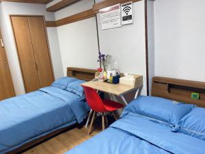 高松市にある瓦町駅·home 301のベッド2台、テーブル、椅子が備わる客室です。