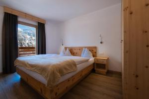 a bedroom with a large bed and a window at Apartments B&B Pretermo in Badia