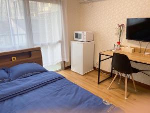 a bedroom with a bed and a desk with a microwave at 瓦町駅.home 401 in Takamatsu