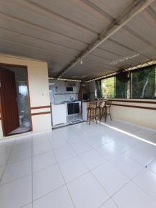 a large room with a white floor and a kitchen at CANTINHO VOLTE SEMPRE in Aparecida