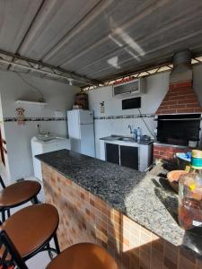a kitchen with a counter and some chairs in a room at CANTINHO VOLTE SEMPRE in Aparecida +3 photos