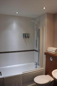 a bathroom with a tub and a toilet and a sink at LuxApartment - Port Of Leith - Free Parking in Edinburgh