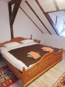 a bedroom with a wooden bed with a brown blanket at Pensiunea Elena in Criţ