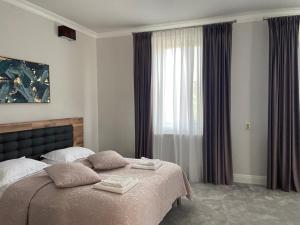 a bedroom with a large bed and a window at Maisonette Apartments in Cîmpulung