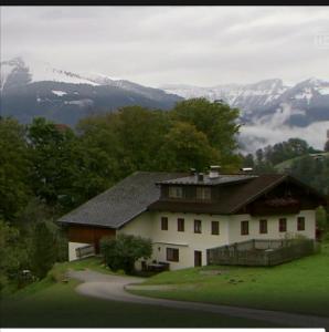 une maison sur une colline avec des montagnes en arrière-plan dans l'établissement Ferienwohnung Löffelberger, à Hallein