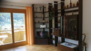 uma sala de estar com televisão e uma parede de prateleiras em Ferienwohnung Maier em Flattach