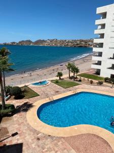 - une vue sur la piscine et la plage dans l'établissement Estudio Frente Al Mar Posada, à San Carlos