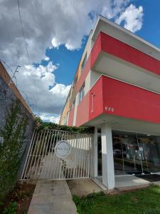 un edificio rojo con una puerta delante de él en Villa Tata Suítes Ltda, en Curitiba