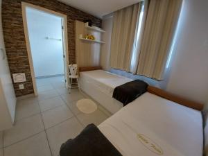 a small room with two beds and a window at Villa Tata Suítes Ltda in Curitiba