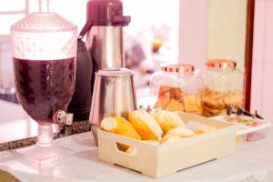 a container of sliced oranges on a counter with a drink at Hotel Silva Votorantim - próximo ao Hospital Santo Antônio in Votorantim