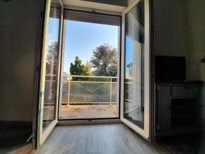 una porta scorrevole in vetro con vista su un balcone di Nuits & Jours Duplex à Nuits Saint Georges a Nuits-Saint-Georges