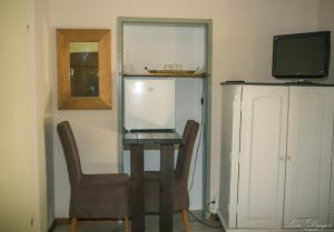 a room with a table and two chairs and a tv at Pensiunea Dulce Ambient in Păuliş