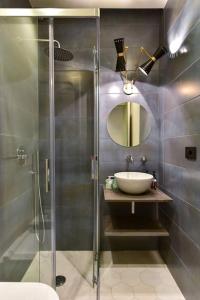 Appartamento Roma San Giovanni في روما: حمام مع دش ومغسلة ومرآة