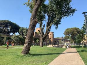 ローマにあるAppartamento Roma San Giovanniの城を背景に植えられた公園内の木