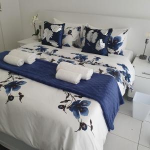 Una cama con sábanas azules y blancas y toallas. en Overport Durban Halaal Accommodation "No Alcohol Strictly Halaal No Parties" Entire Luxury Apartment, 2 Bedroom, 4 Sleeper, Self Catering, 300m from Musjid Al Hilaal en Durban