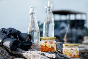 duas garrafas de vidro e uma câmara numa mesa em Makini Bush Camp, Yala em Yala