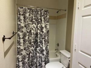 a bathroom with a toilet and a shower curtain at Resort Style Apt/Home in Houston Medical Centre in Houston