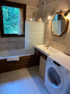 een badkamer met een wasmachine en een wastafel bij Loge des rêveurs in Les Carroz d'Araches