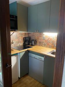 a small kitchen with blue cabinets and a sink at Loge des rêveurs in Les Carroz d'Araches
