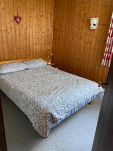 una camera con un letto su una parete in legno di Loge des rêveurs a Les Carroz d'Araches